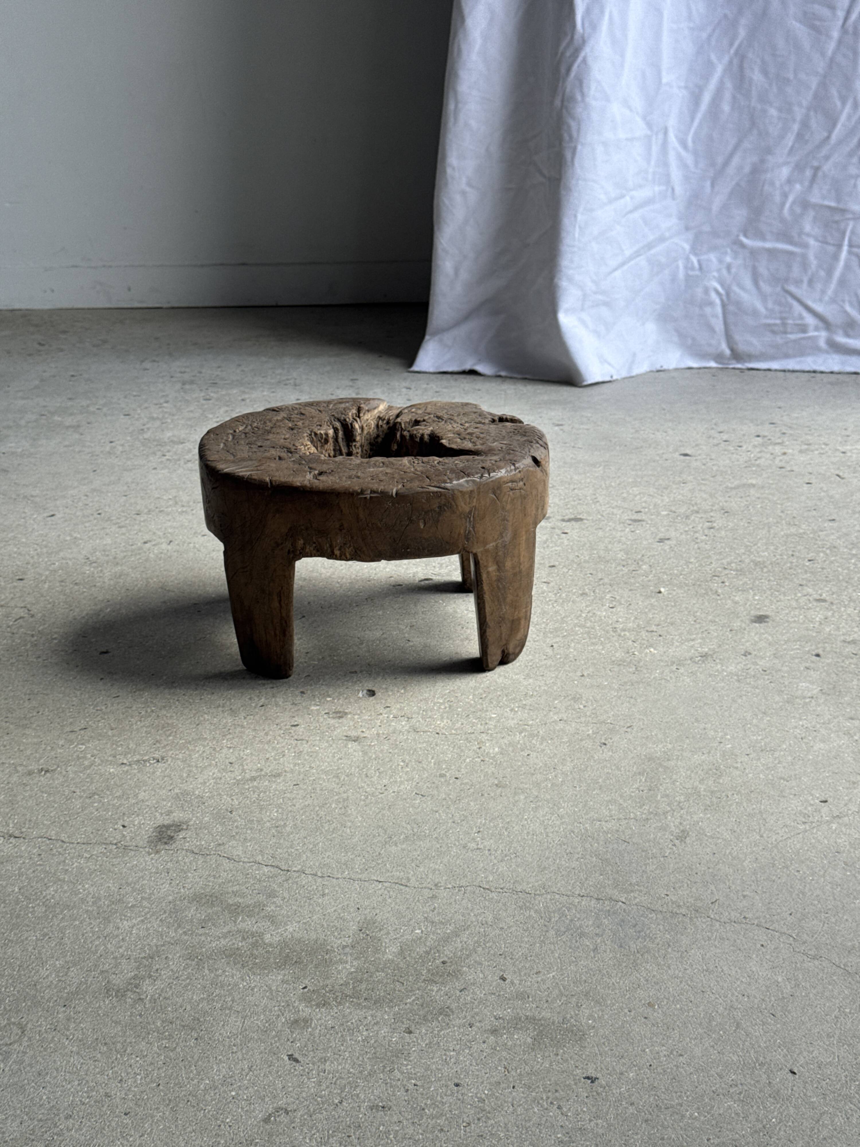 Small low circular four-legged stool in organic old teak with cut-out design H2