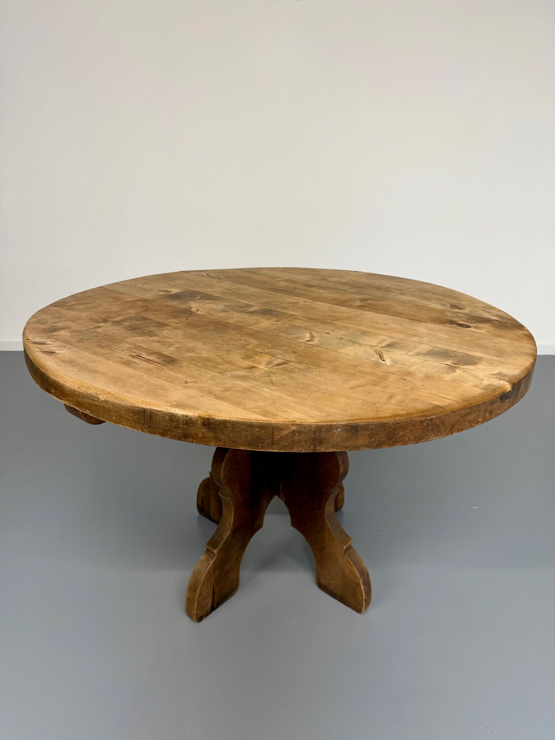 Round table in solid wood, thick top, vintage brutalist style from the 1960s.