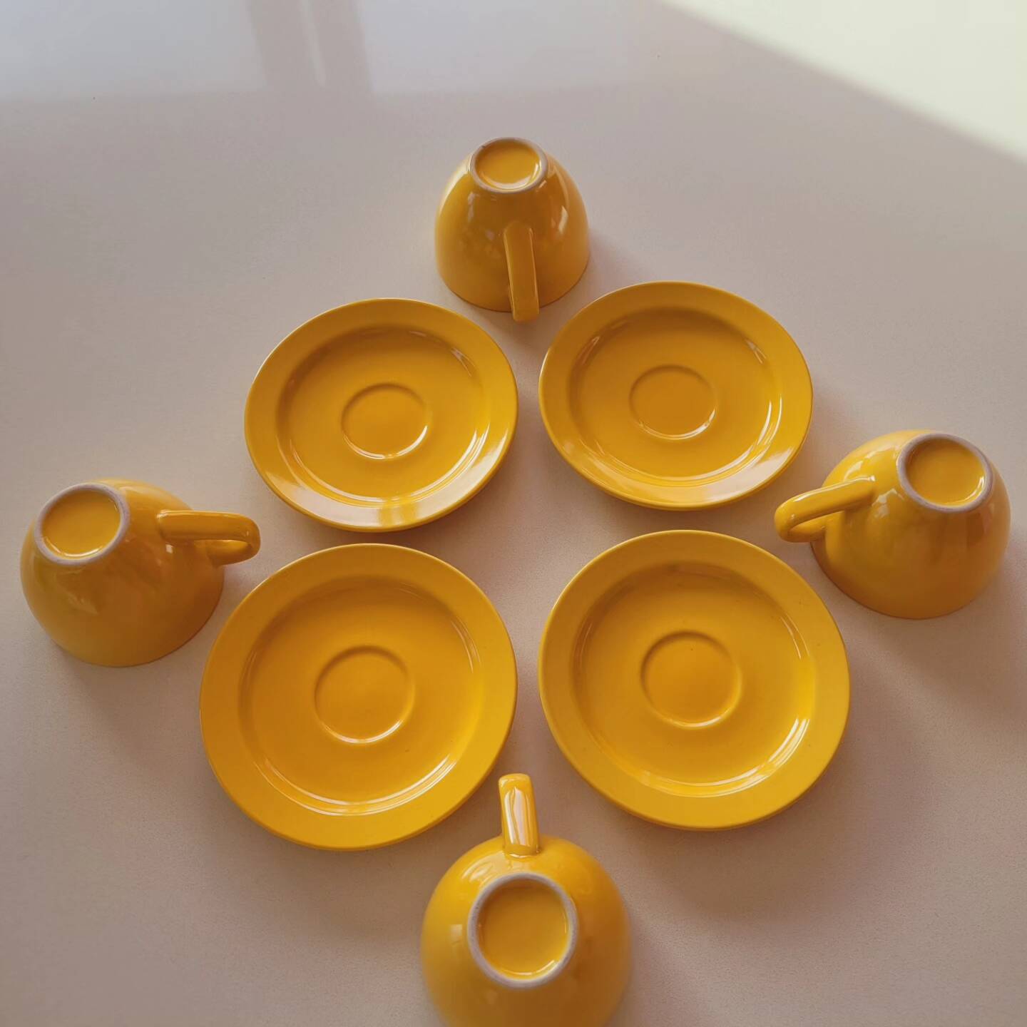 4 yellow cups and saucers