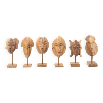 Six African masks mounted for display in wood, 1970s.