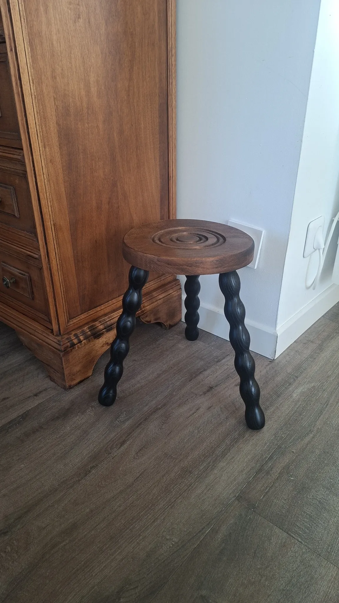 Brown and black wooden tripod stool