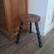 Brown and black wooden tripod stool