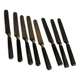 A set of 8 knives with black wooden handles