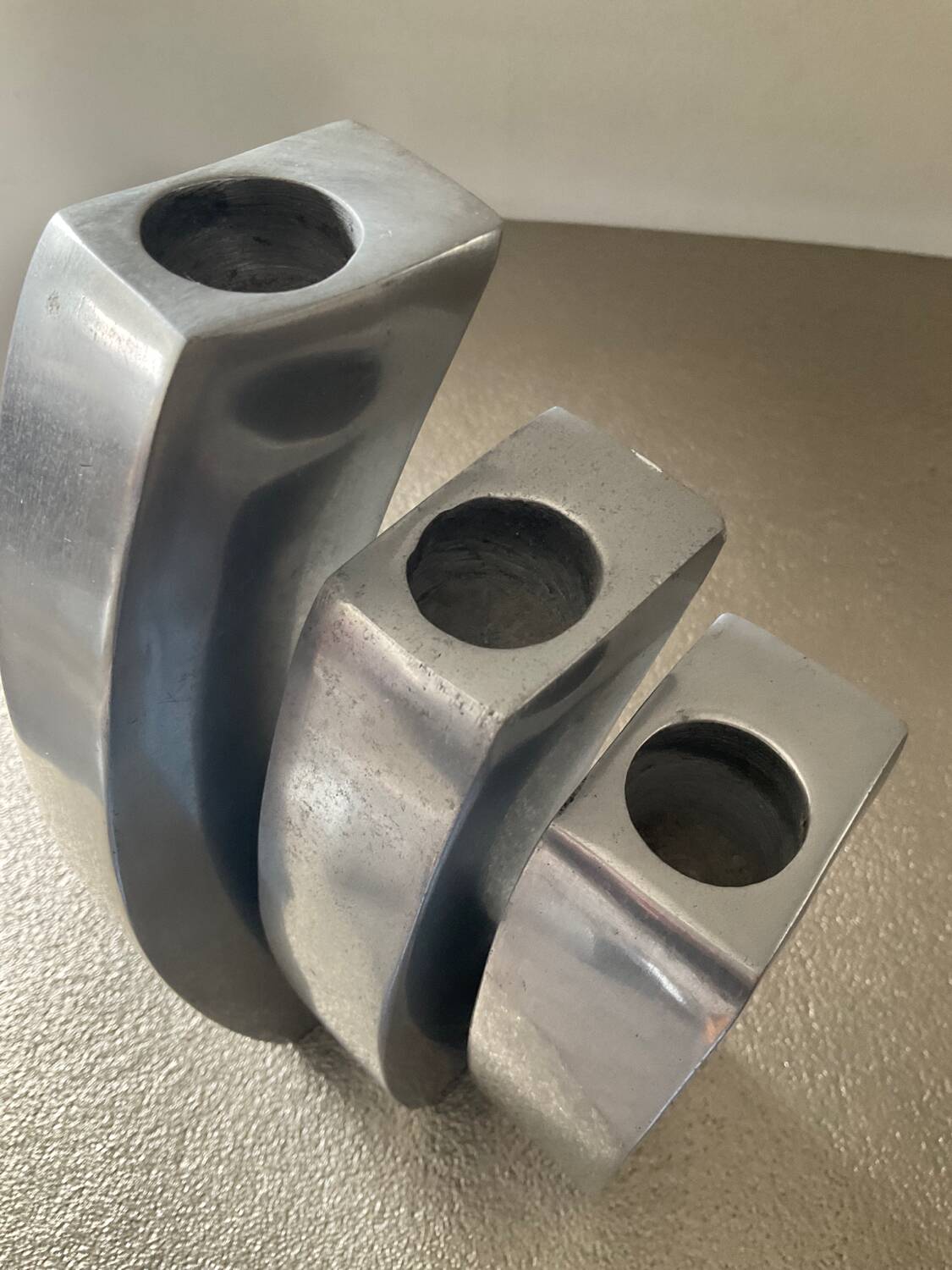 Trio of cast aluminum candle holders