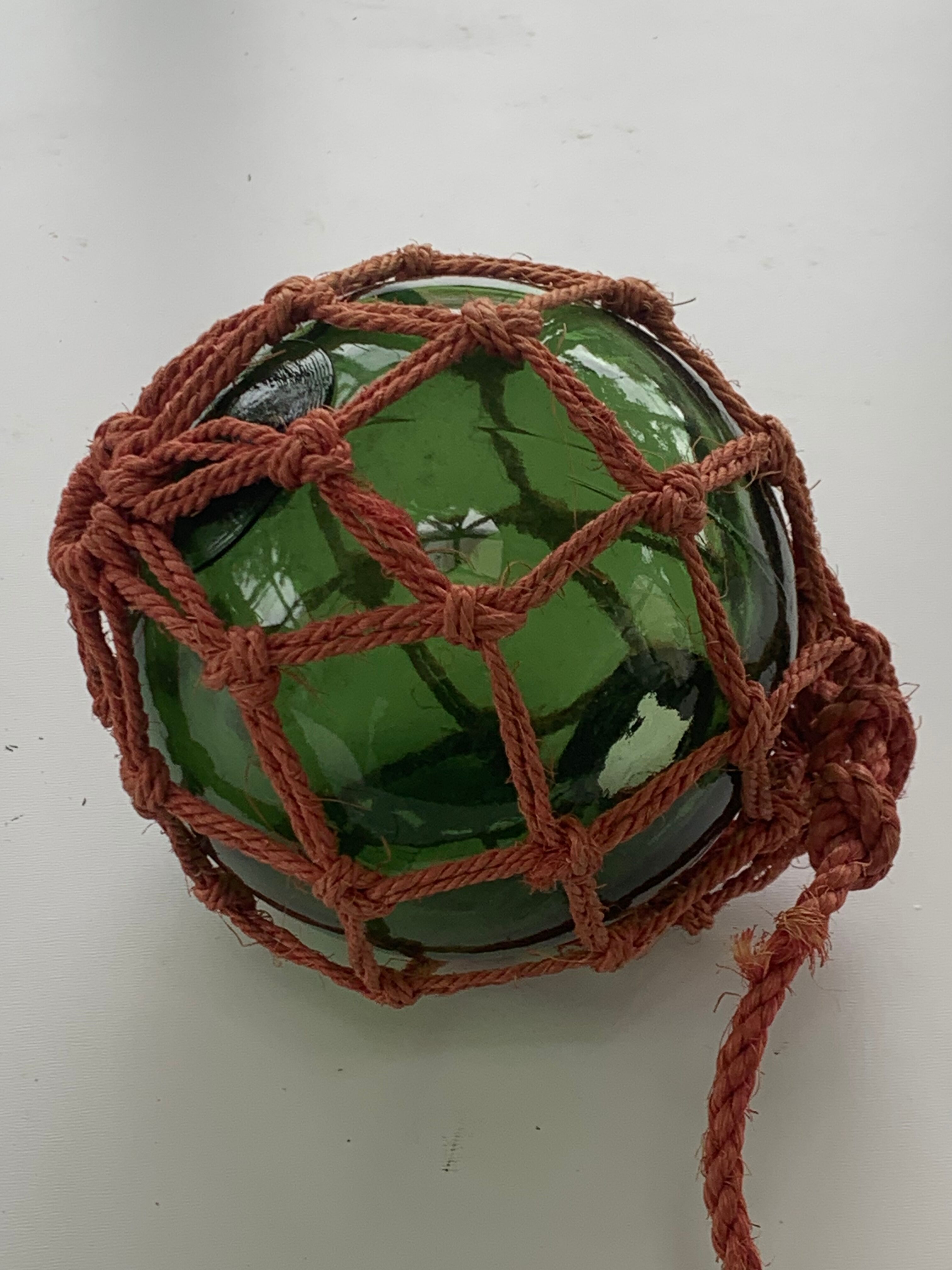 Globe, green glass float and vintage rope