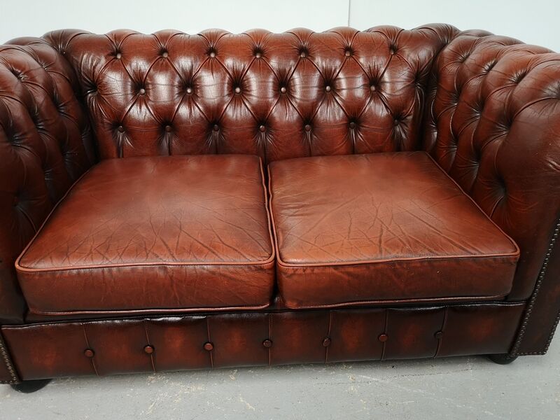 Two-seater brown leather chesterfield sofa
