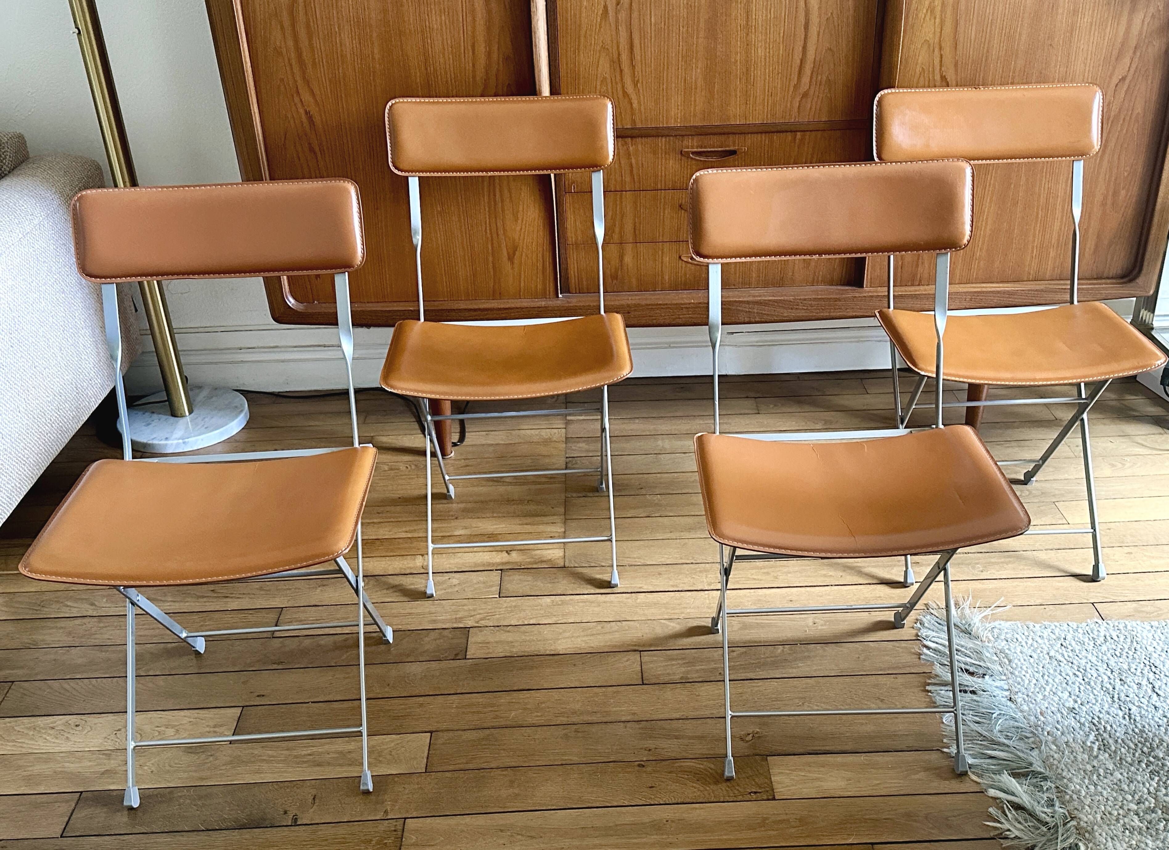 4 folding Sintesi chairs for DWR Lina in metal and vintage camel leather.
