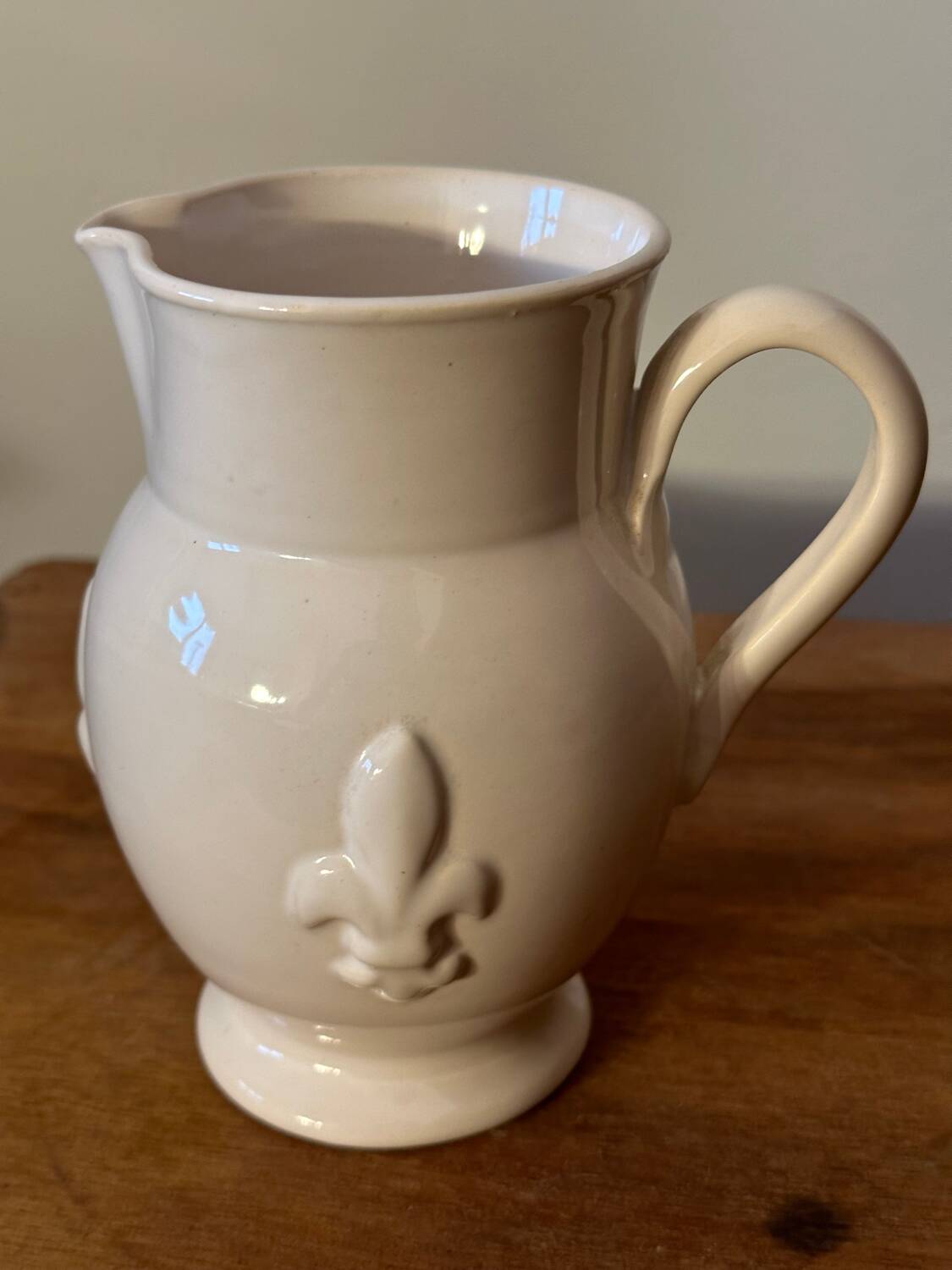 Old white ceramic pitcher with fleur de lys in relief h 14 cm