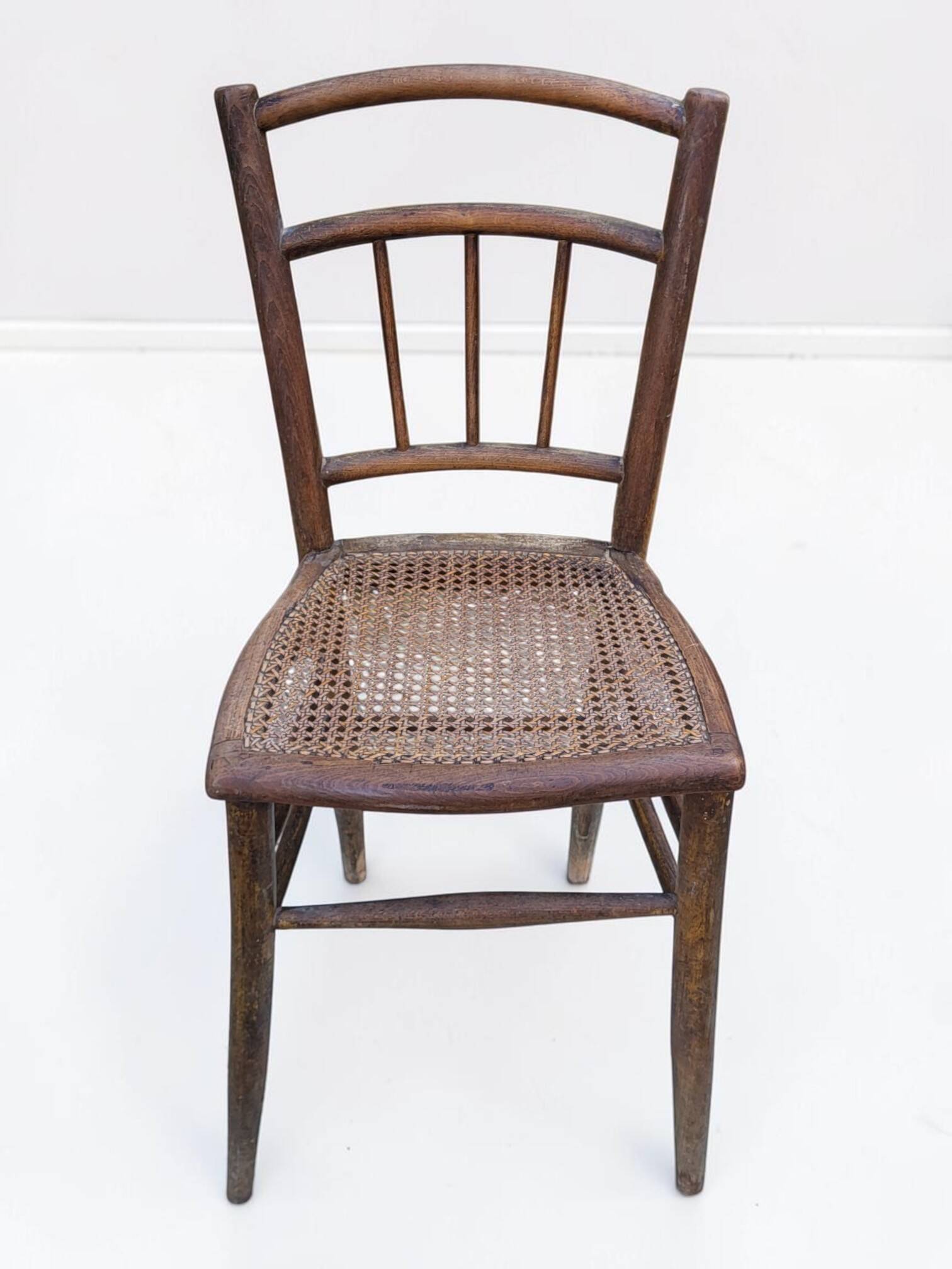 Chair with a slatted backrest and caned seat.