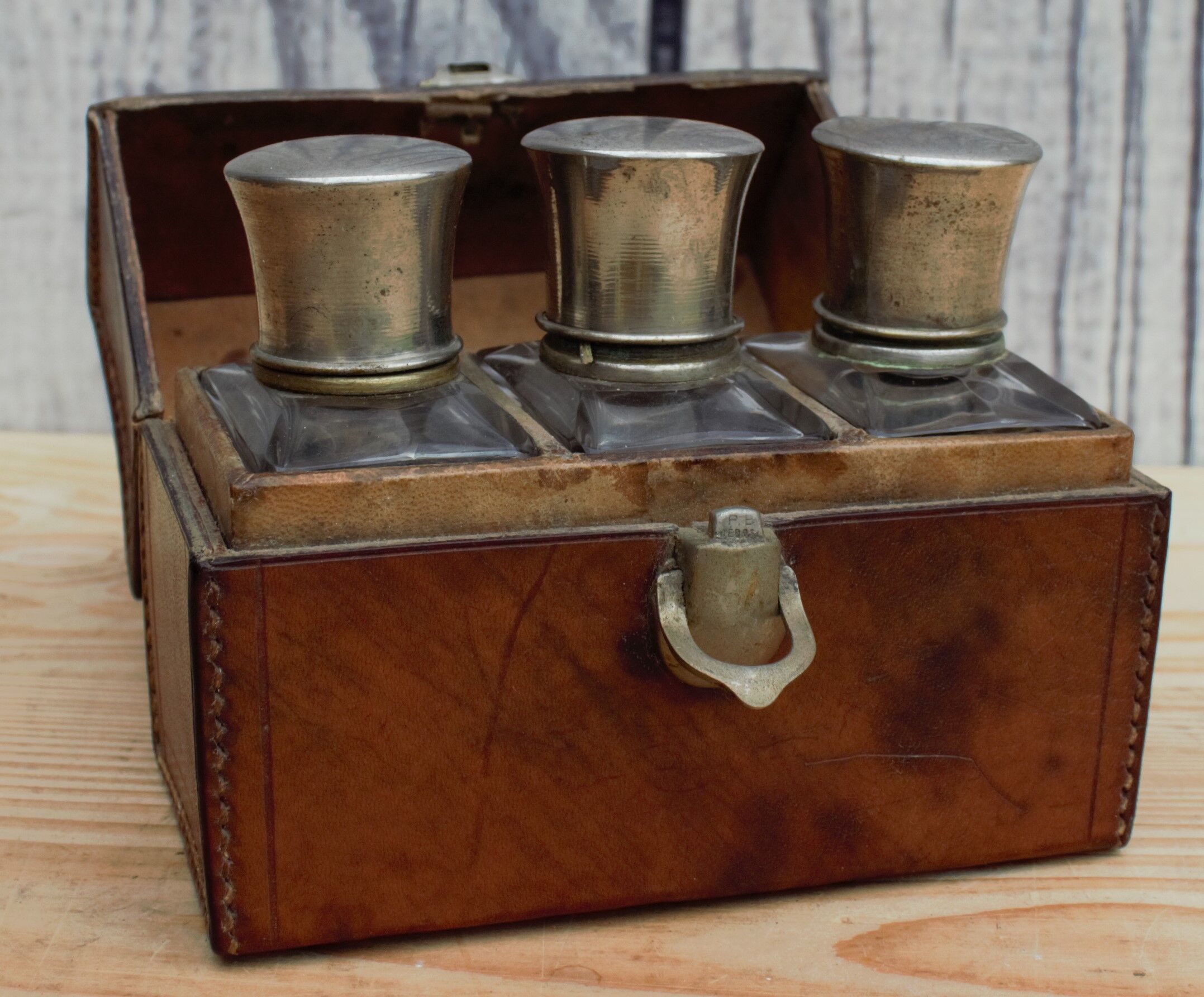 Antique leather case with 3 beveled bottles