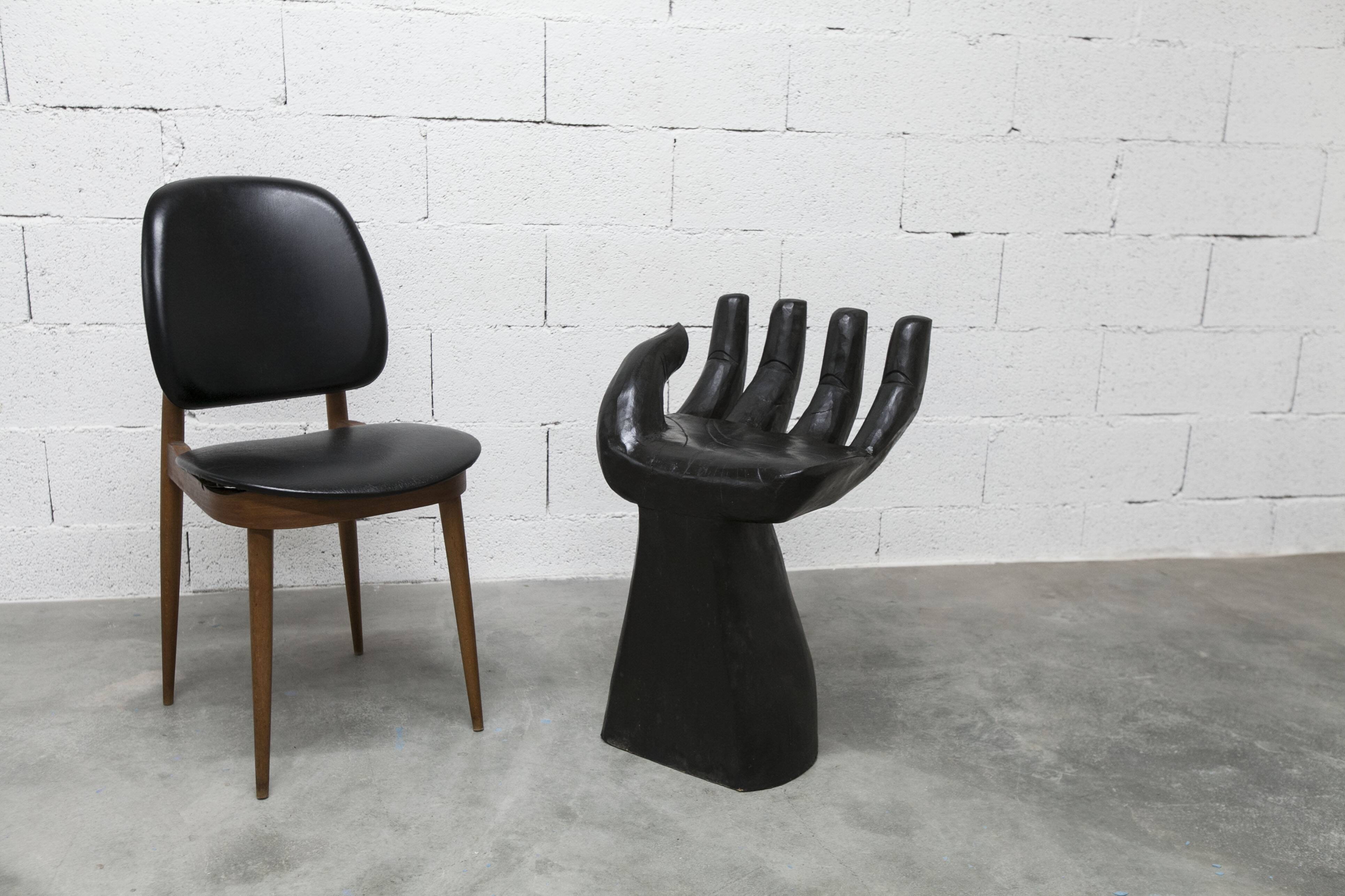Black armchair chair in carved wood in the shape of a hand