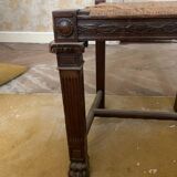 Antique carved wooden chairs with straw seats.