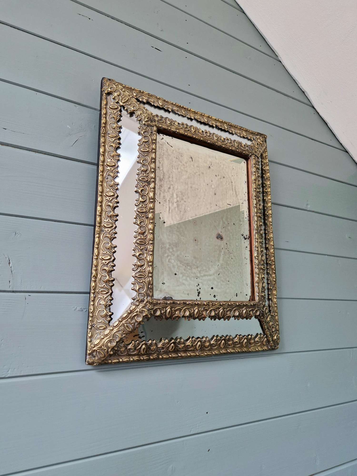 Mirror with repoussé brass frame, mercury glass, 19th century.