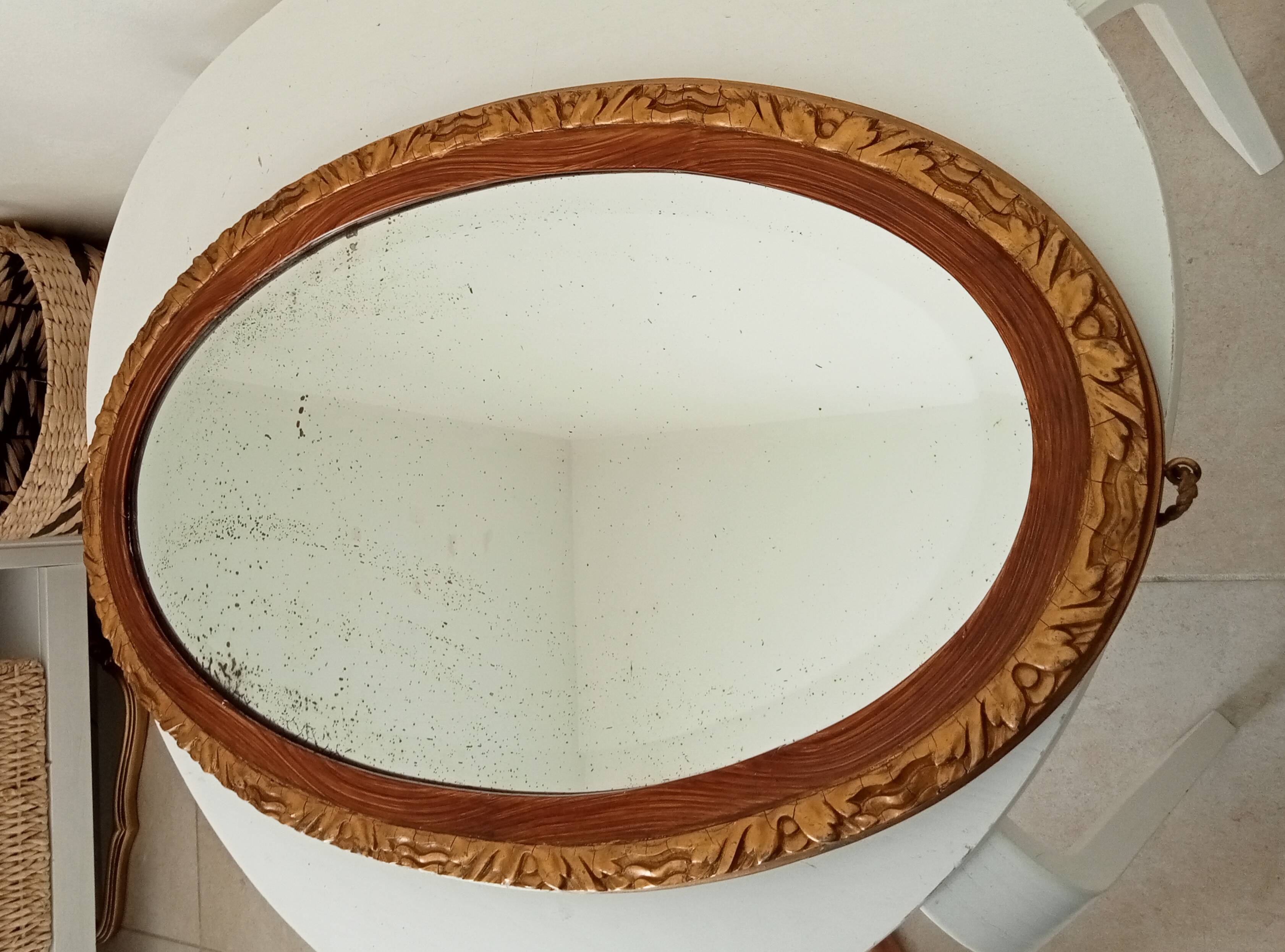Antique oval mirror with beveled glass in wood and stucco, 19th century