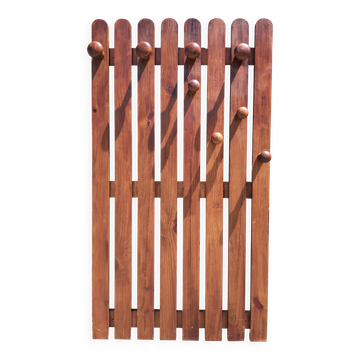 Wall-mounted coat rack in wood or wall hook.
