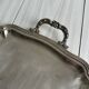Silver metal serving tray with sculpted handles