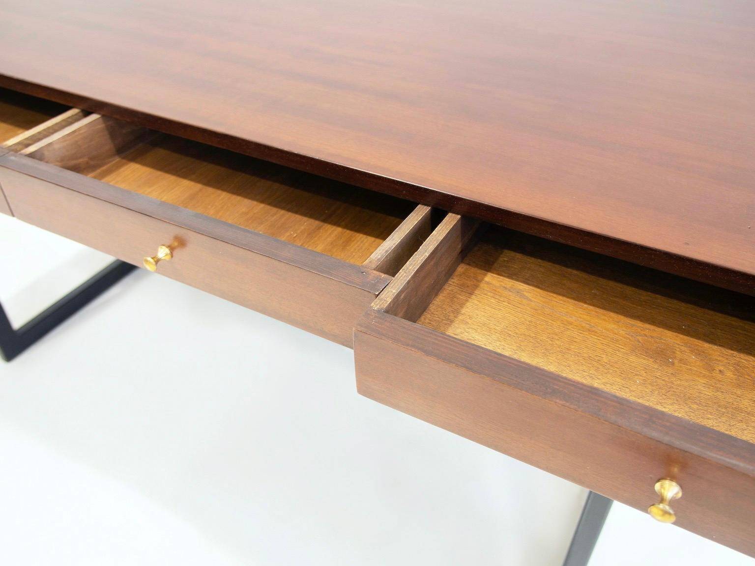 Wooden desk with drawers and black lacquered legs.