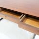 Wooden desk with drawers and black lacquered legs.