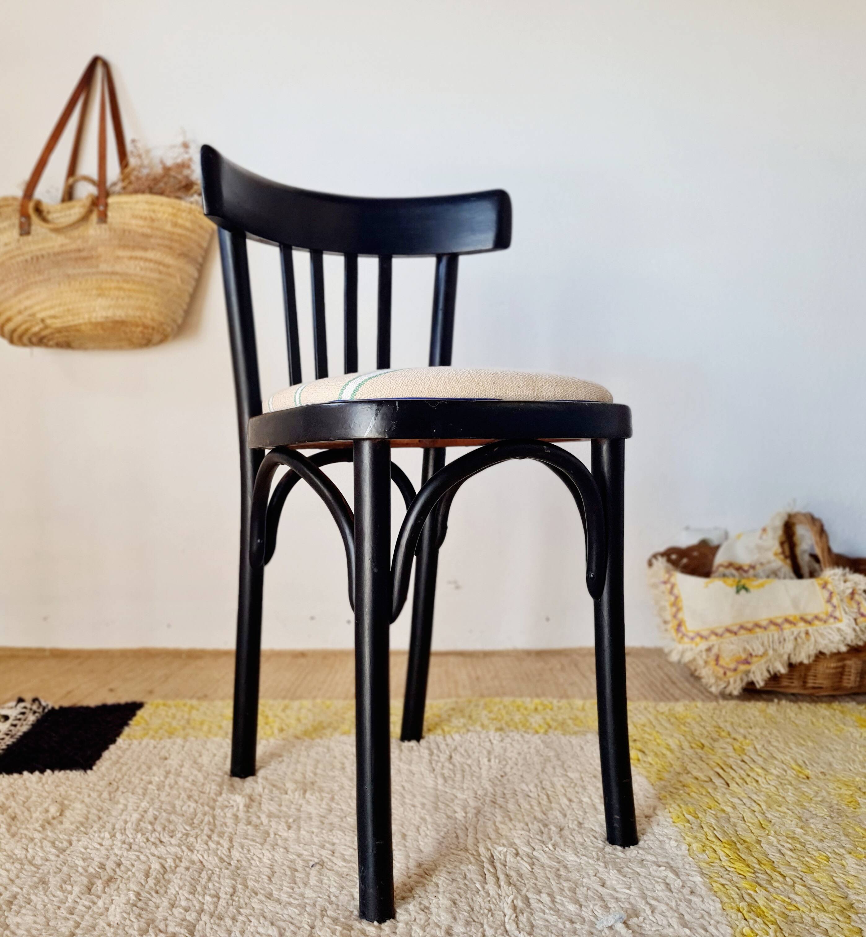 Curved black wooden bistro chair with striped seat