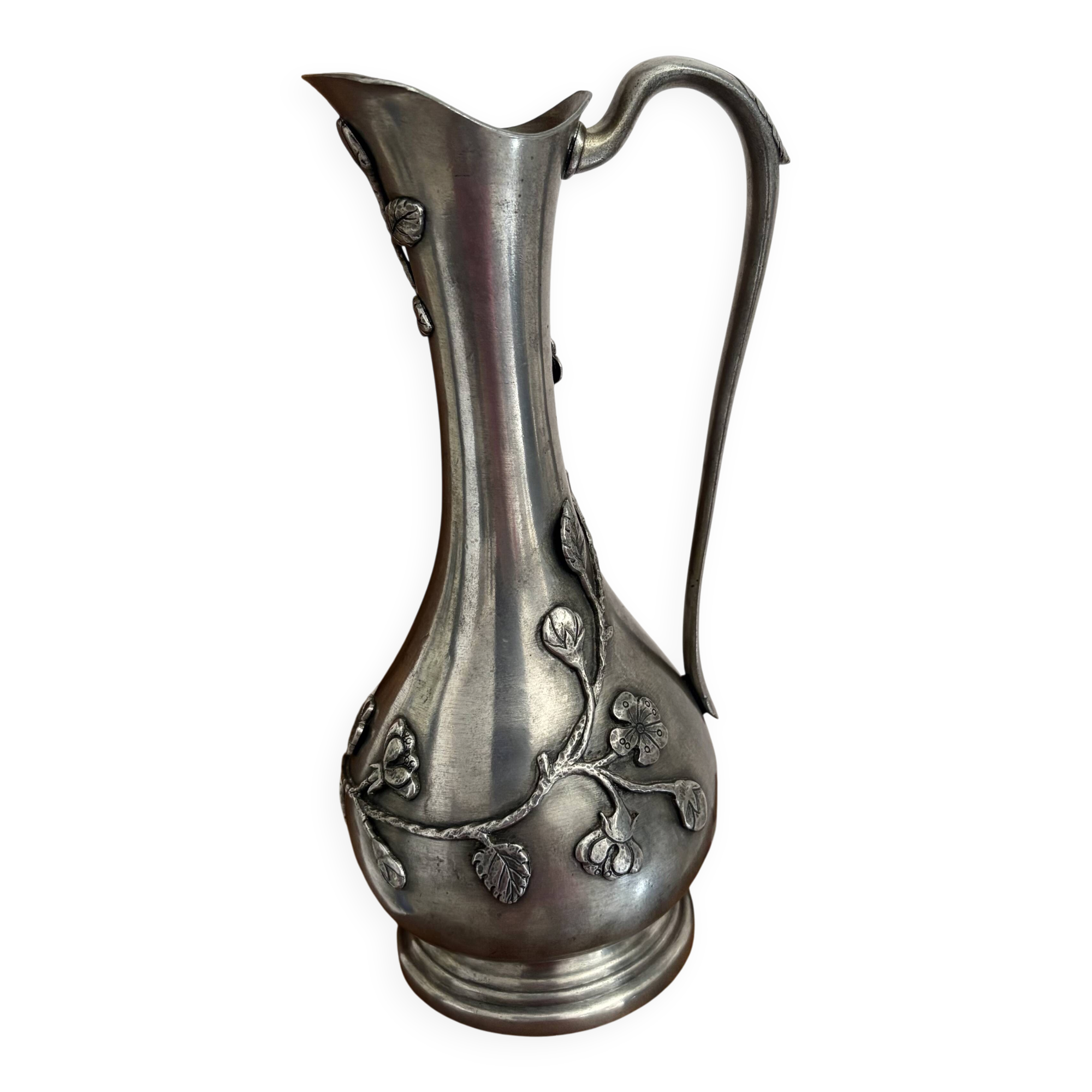 Carafe The House of Tin surrounded by ivy branches.