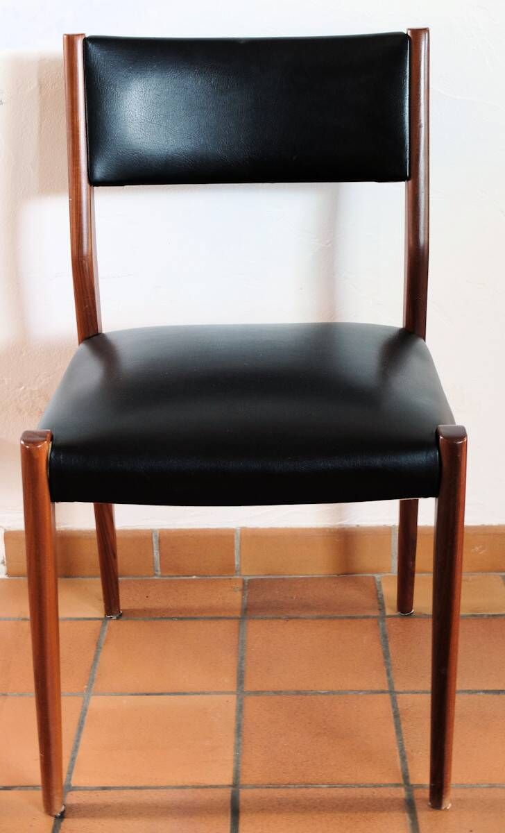Four antique Scandinavian-style chairs made of solid wood and faux leather.