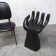 Black armchair chair in carved wood in the shape of a hand