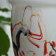Corolla vase in white opaline with orange-brown patterns.