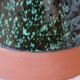 Sculptural ceramic vase with dark green glaze and shimmering highlights