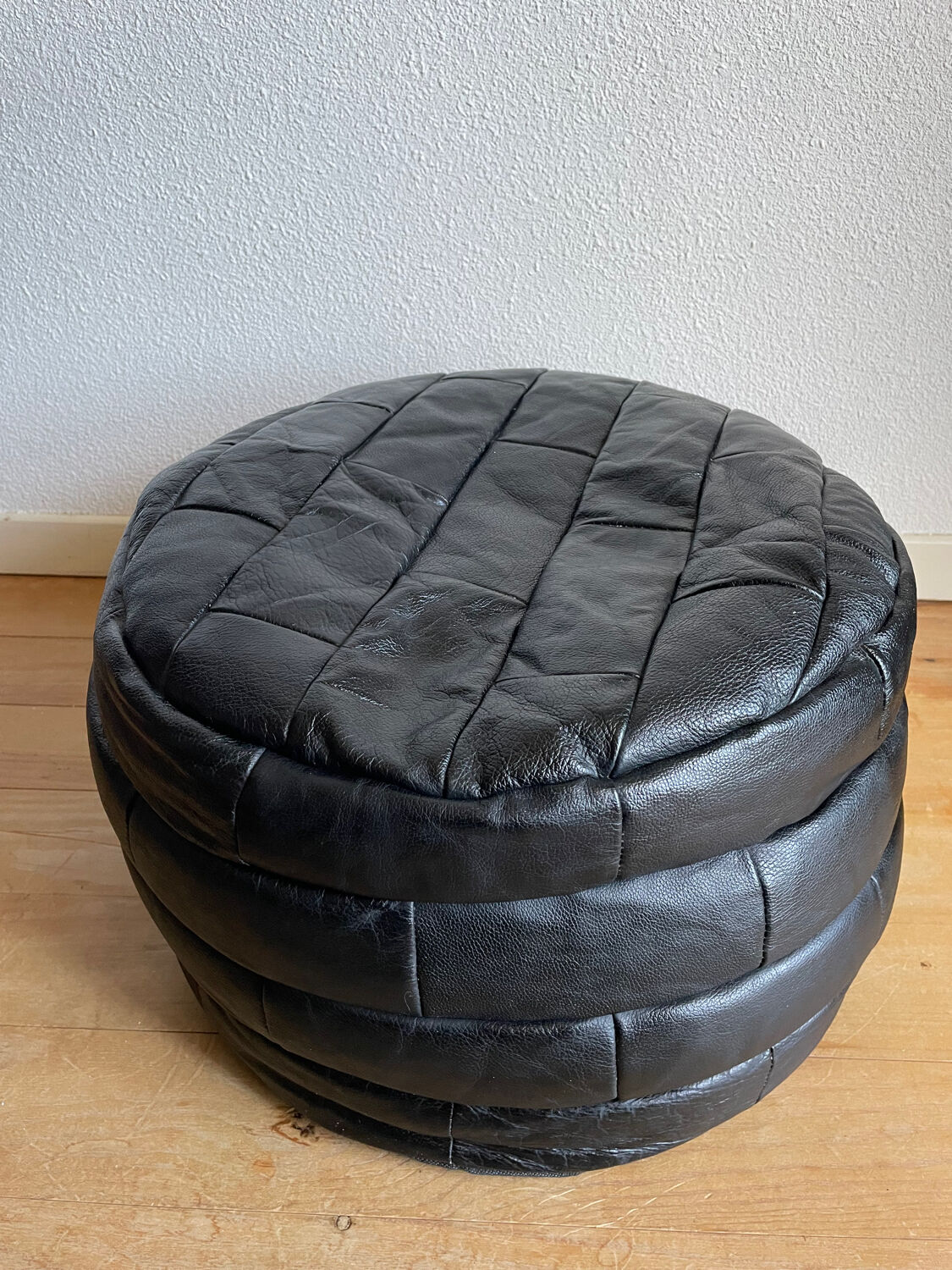 Patchwork black leather pouf de Sède