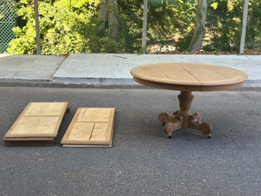 Round dining table with a central pedestal, stripped raw oak, 4 extensions, 19th century.