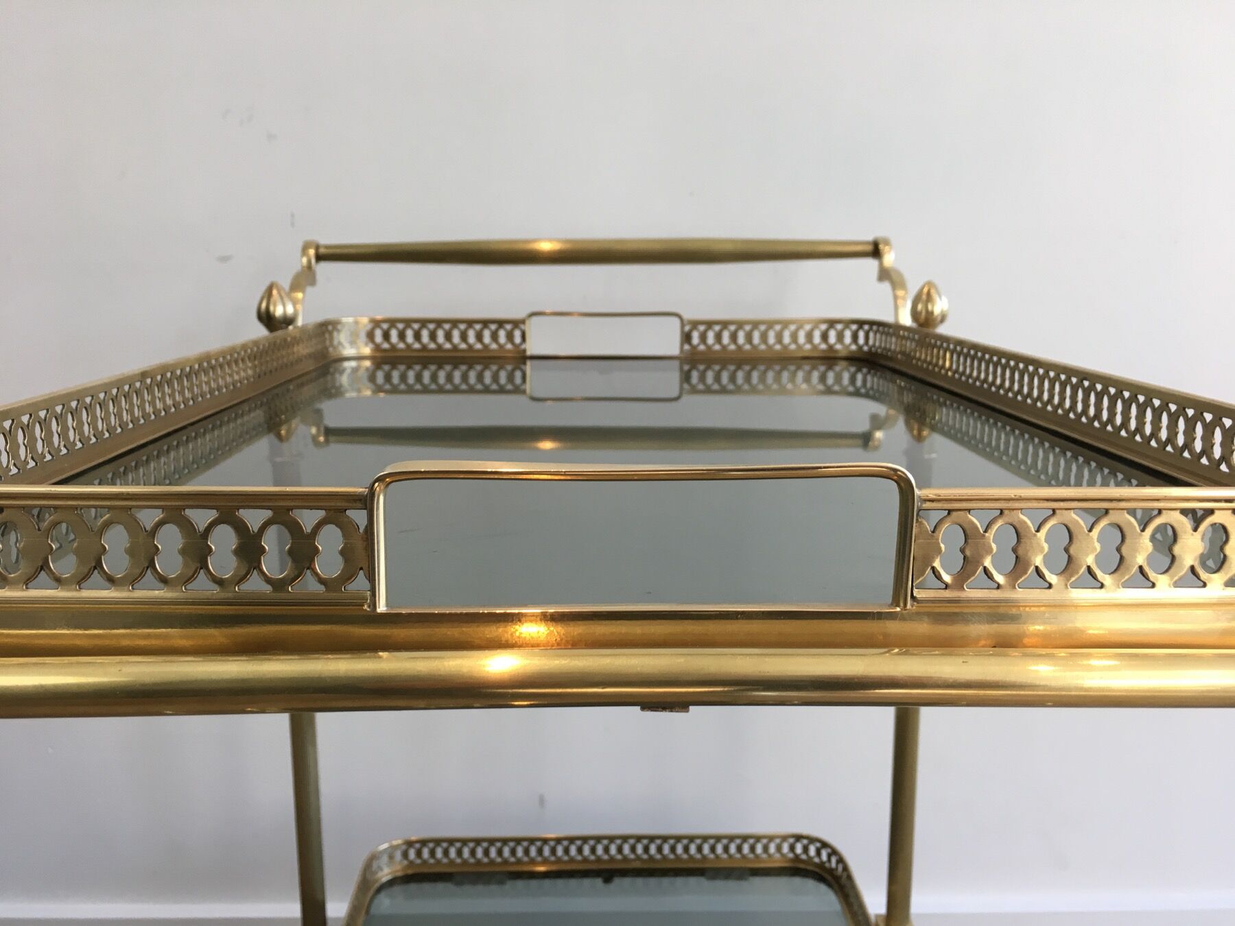 Neoclassical style rolling table in brass with blue glass tops