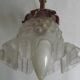 Simple wall sconce in French Art Nouveau bronze with a white glass shade featuring patterns.