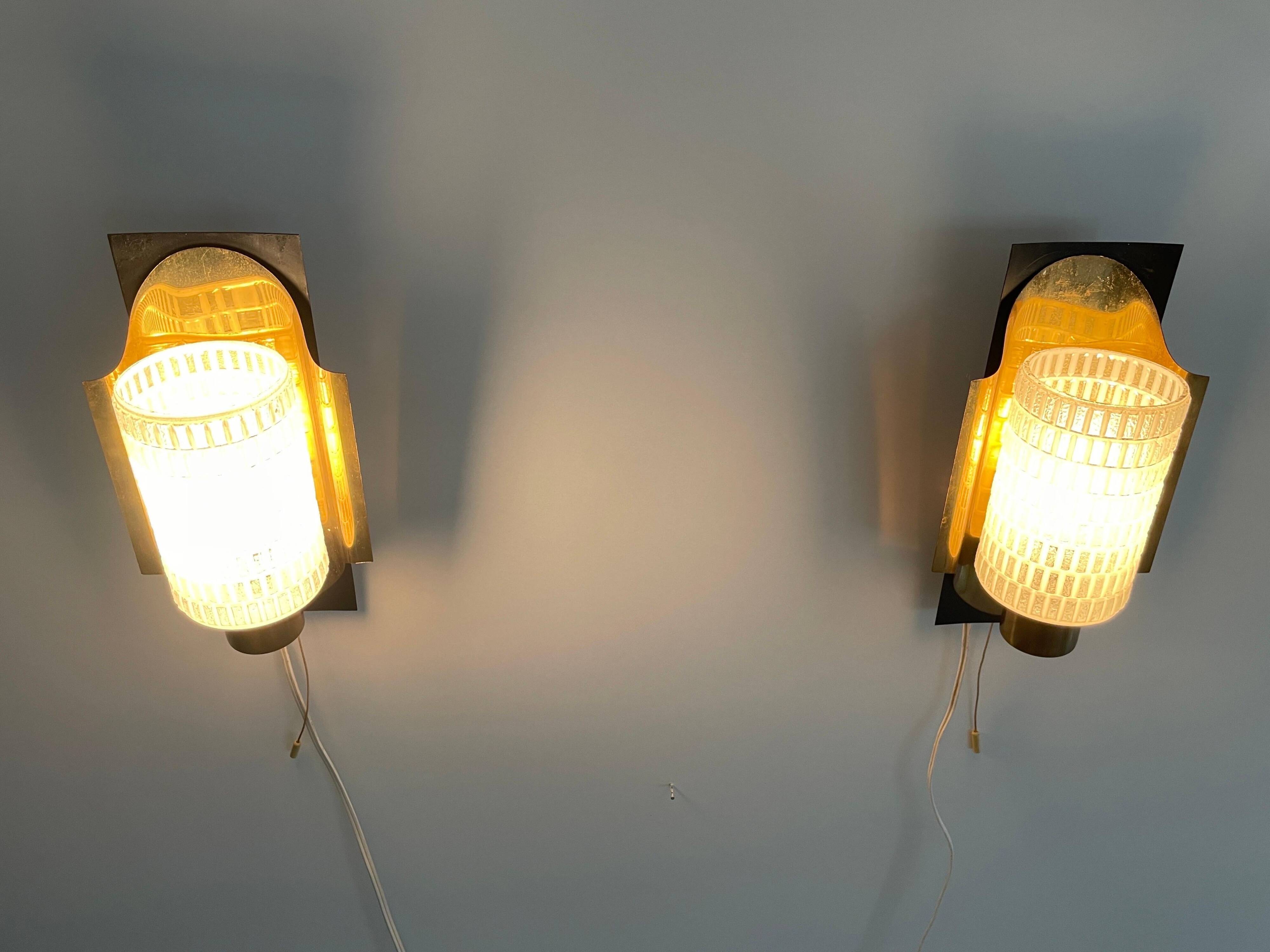 Mid-century pair of wall sconces in textured glass and brass, 1950s, Germany.
