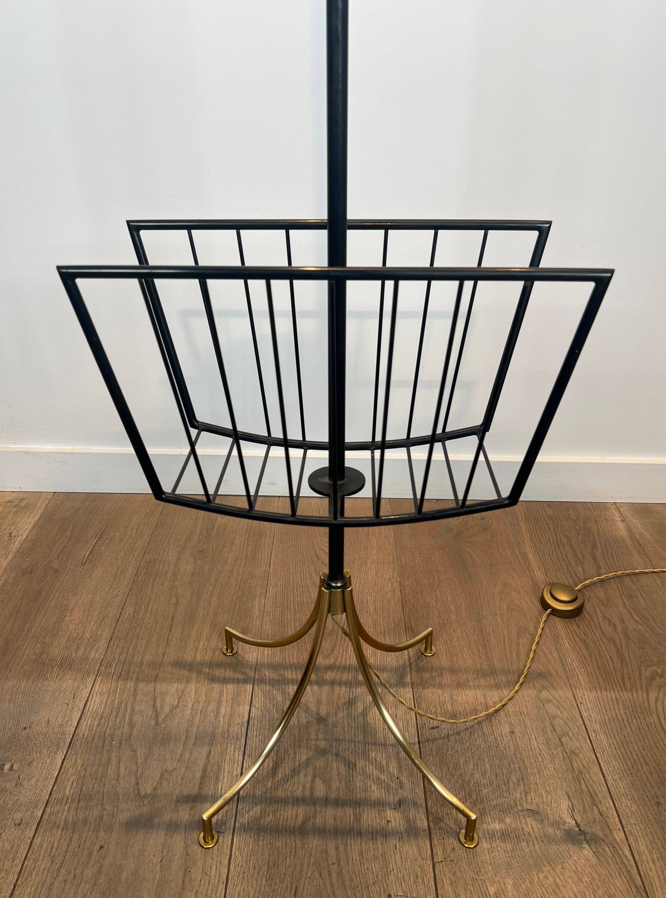 Designer floor lamp in black lacquered metal and brass, incorporating a magazine rack