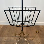 Designer floor lamp in black lacquered metal and brass, incorporating a magazine rack