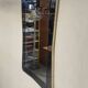 1950s double-thickness wall mirror with brass profile and supports.