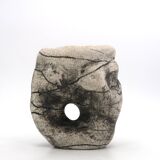 Ceramic vase sculpture decorated with faces and featuring a hole, 1980s.