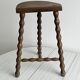 Three-legged demi-lune stool made of turned wood