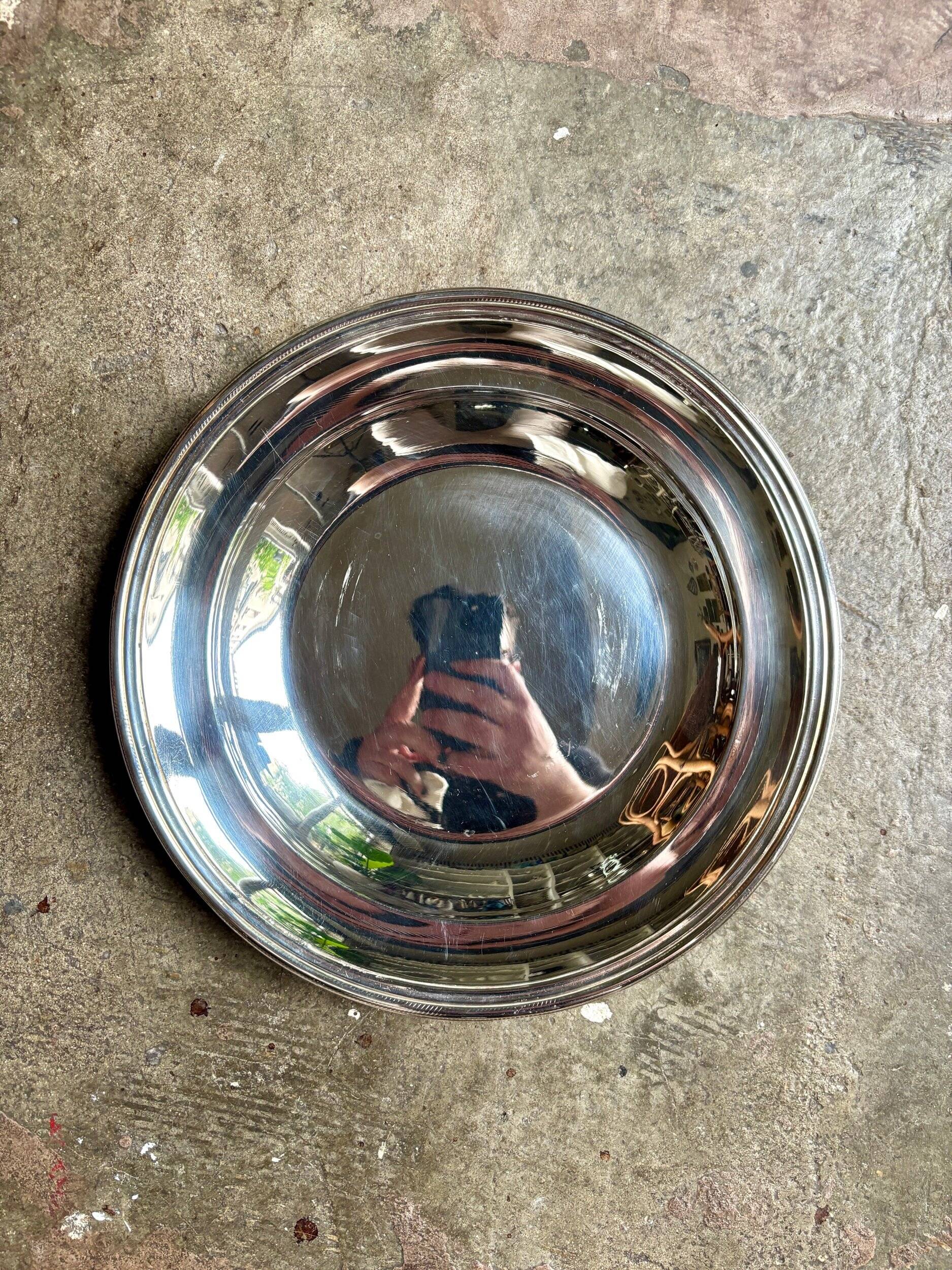 Round, hollow silver-plated metal dish