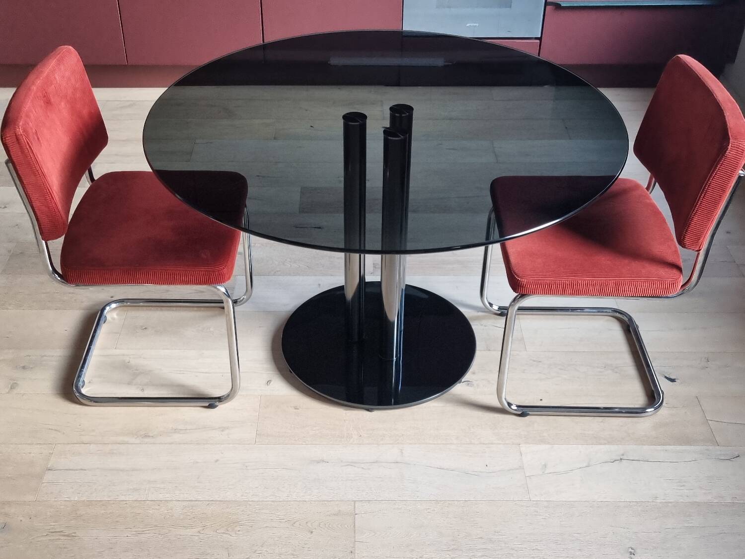 Round black smoked glass dining table + 2 terracotta chairs