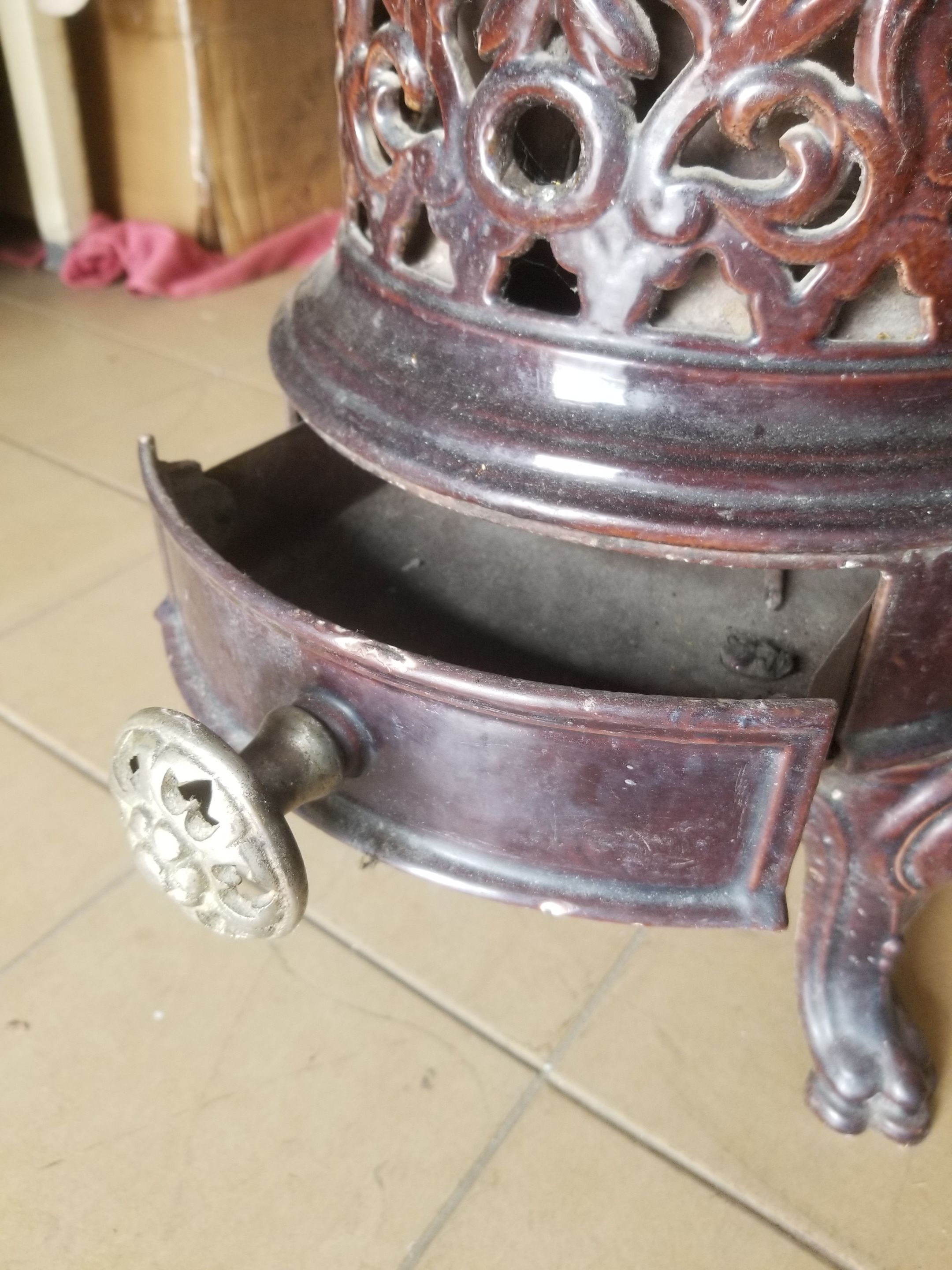 Old compact wood stove in enamelled cast iron with tripod feet with Lion's legs
