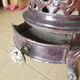 Old compact wood stove in enamelled cast iron with tripod feet with Lion's legs