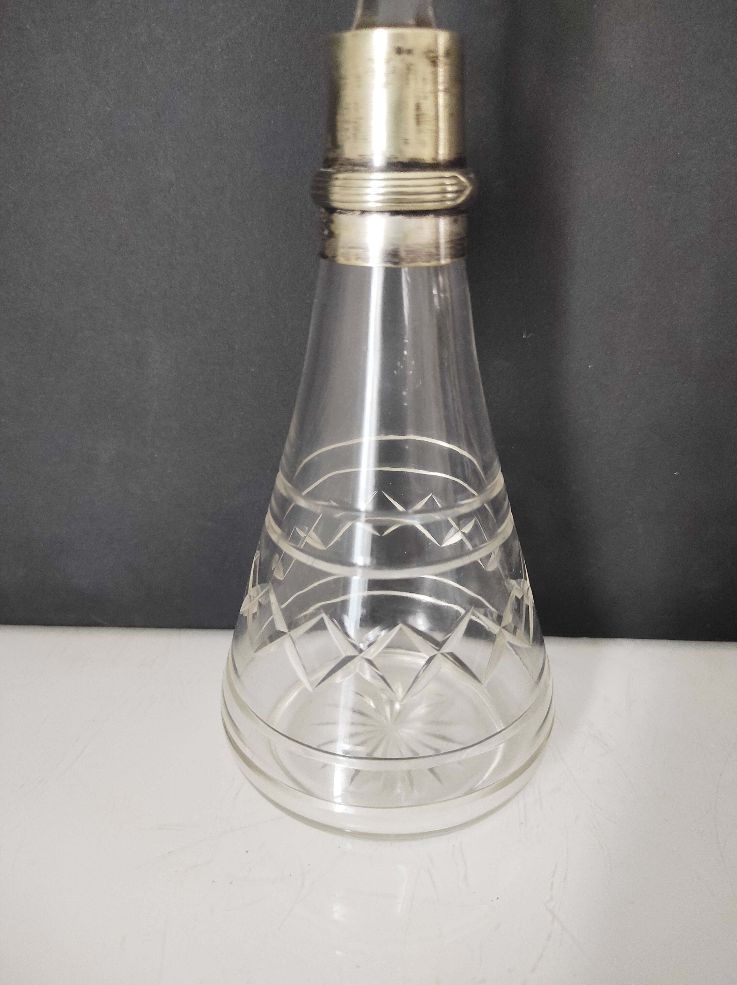 Crystal bottle with silver metal neck rim