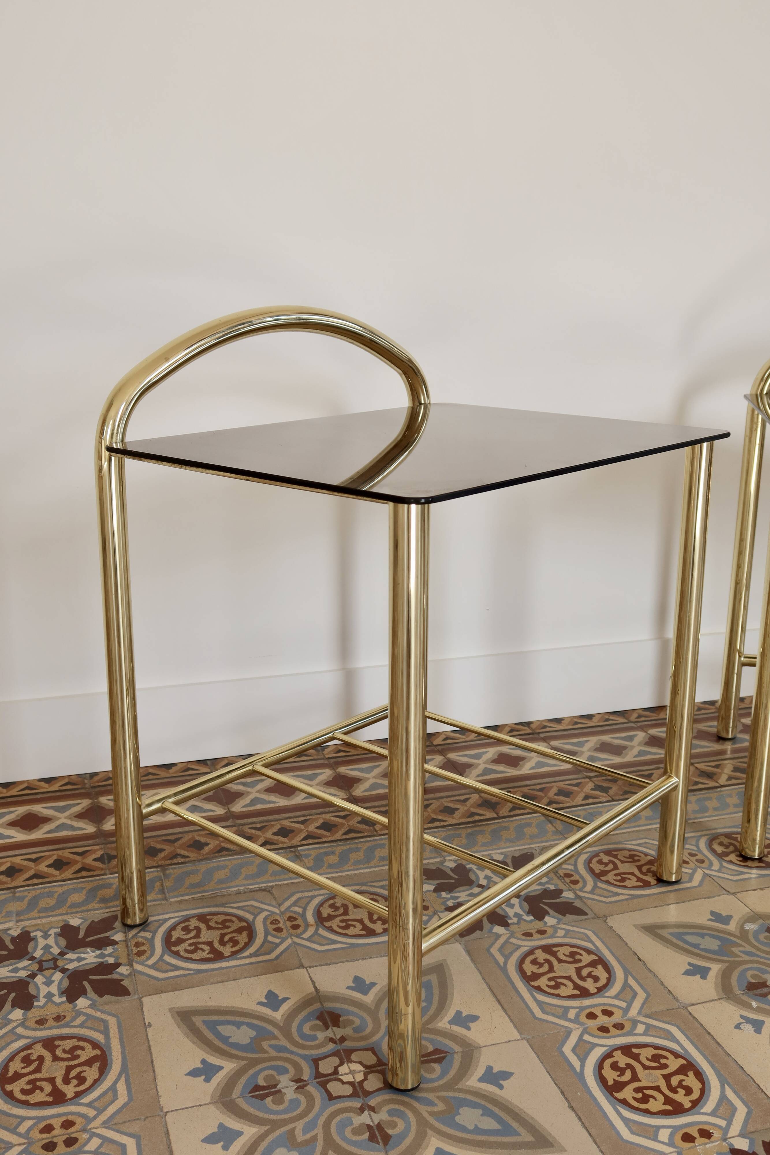 Pair of bedside tables with gold metal and mirrored glass top.