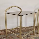 Pair of bedside tables with gold metal and mirrored glass top.