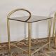 Pair of bedside tables with gold metal and mirrored glass top.