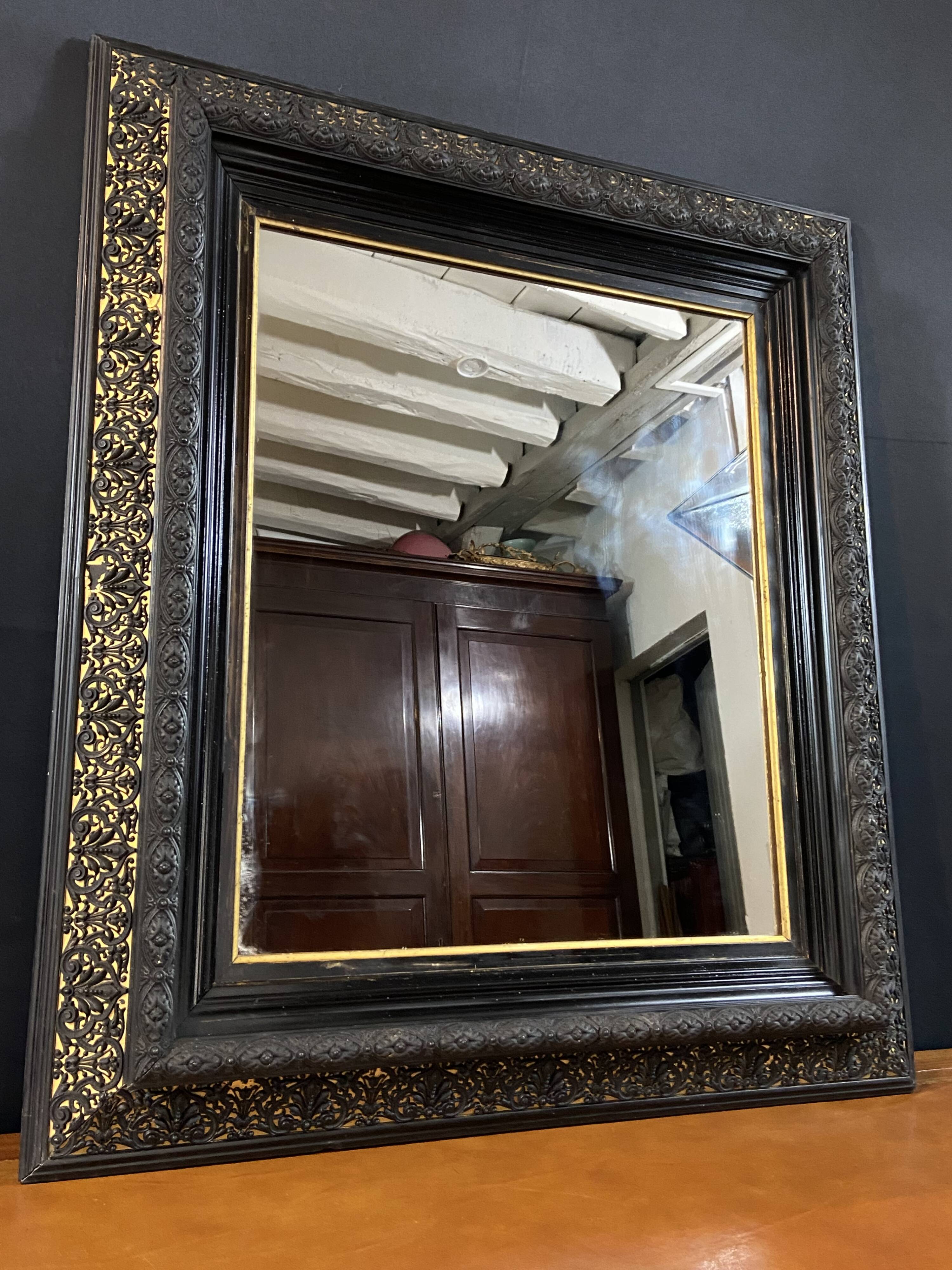 19th-century mirror Napoleon III in blackened wood on a gold background.