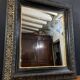 19th-century mirror Napoleon III in blackened wood on a gold background.