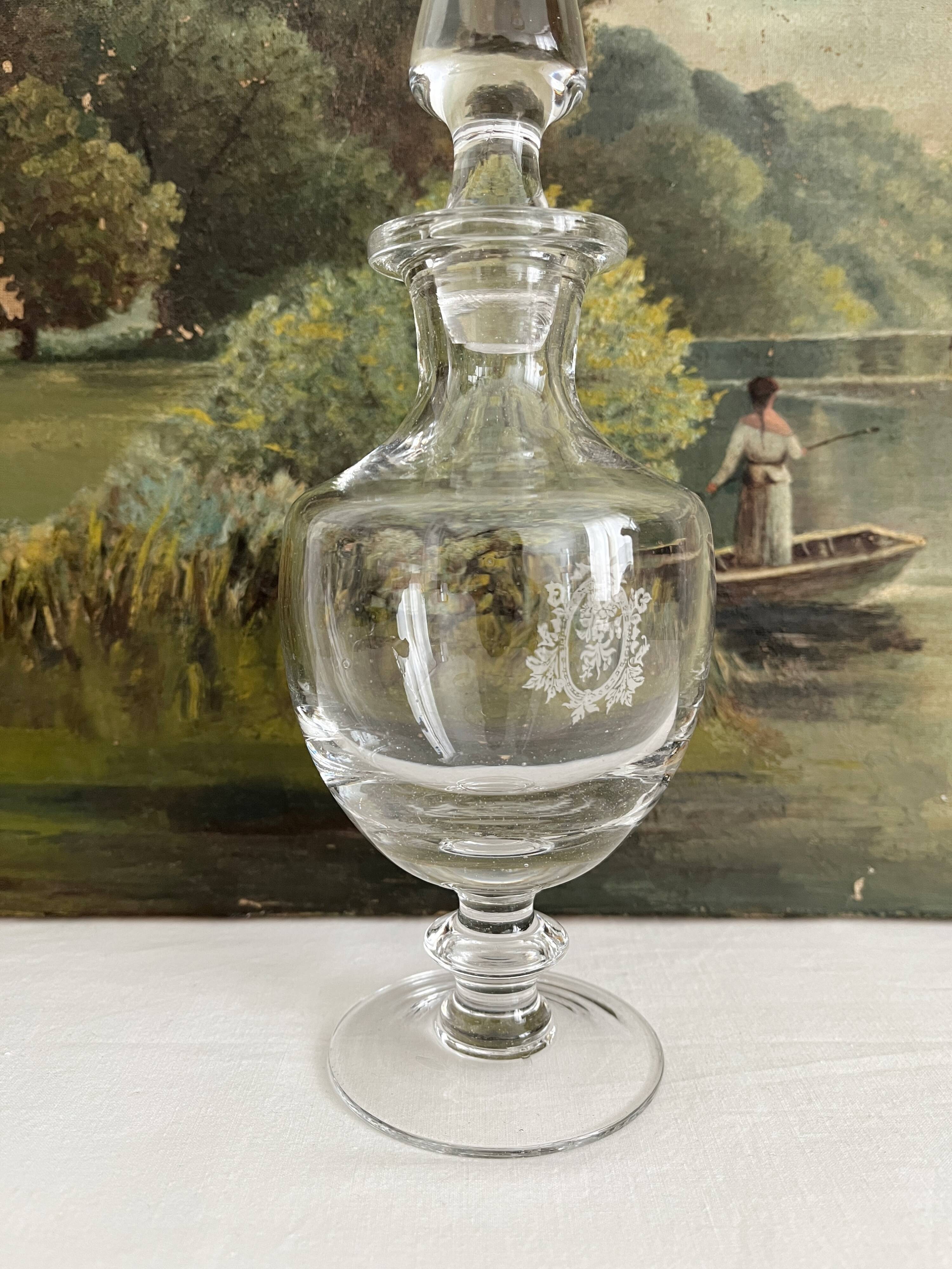 Antique stemmed blown glass bottle with engraved medallion
