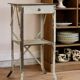 Painted metal side table, patinated white, with a drawer and two shelves